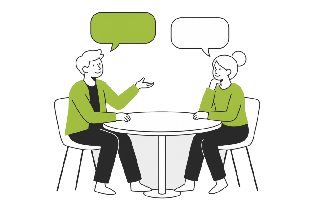 Two people talking at a small table, each with their own speech bubble